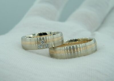 Trauringe aus Weißgold und Rosegold mit drei Brillanten