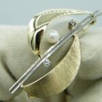 Brosche aus 585er Gelb- und Weißgold mit zwei Brillanten und einer Perle