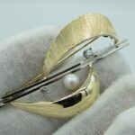 Brosche aus 585er Gelb- und Weißgold mit zwei Brillanten und einer Perle